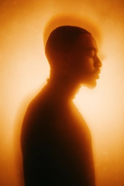 A man in silhouette, wrapped in a warm glow