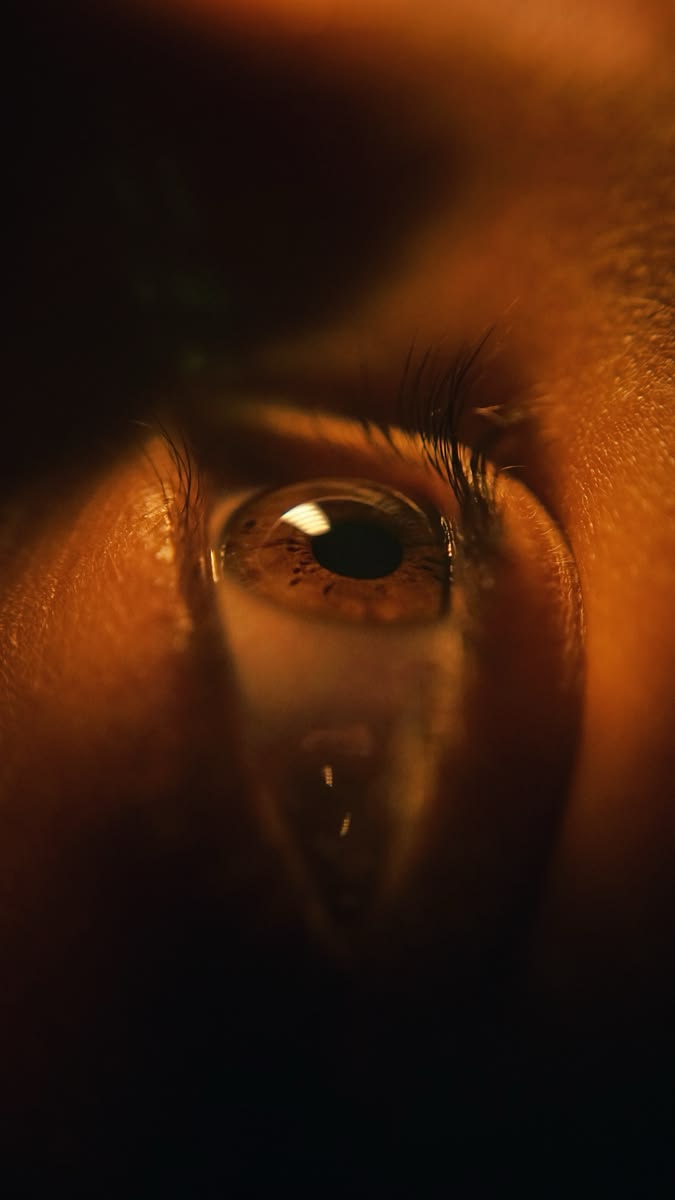 A close-up of an eye in low amber light