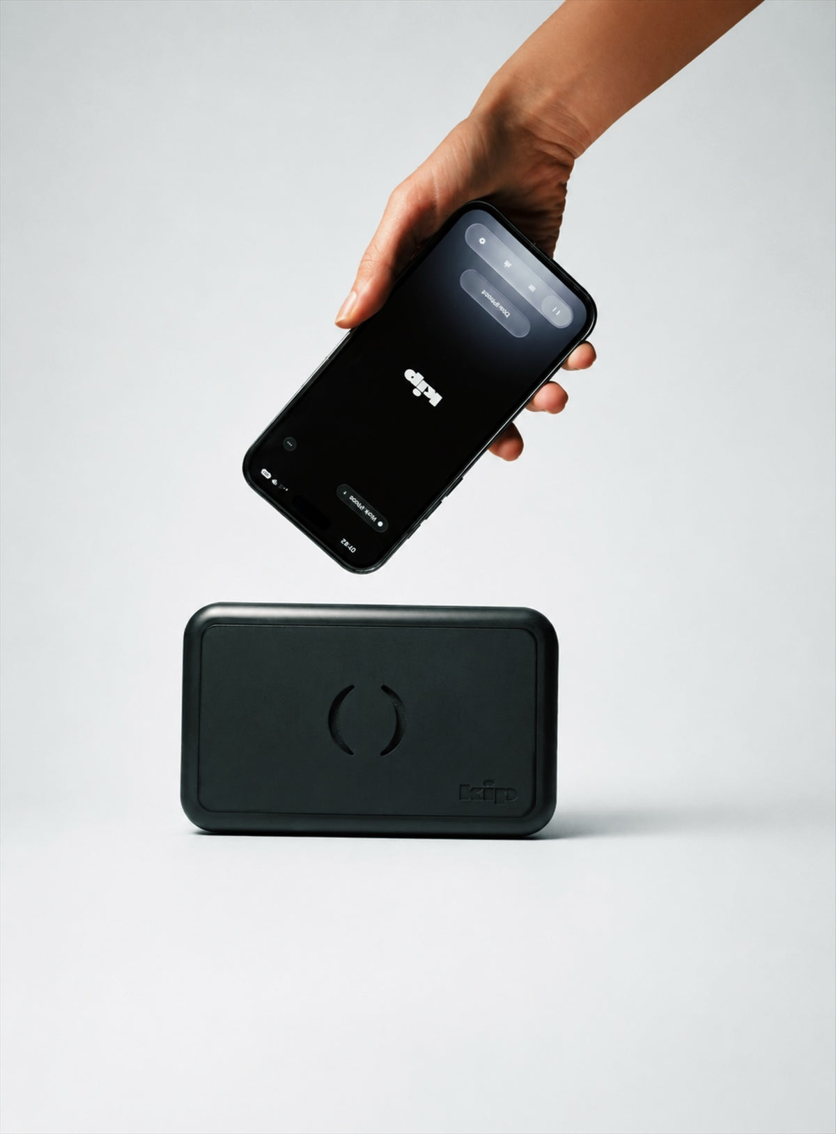 A member taps their phone on a kip tag on a brick wall